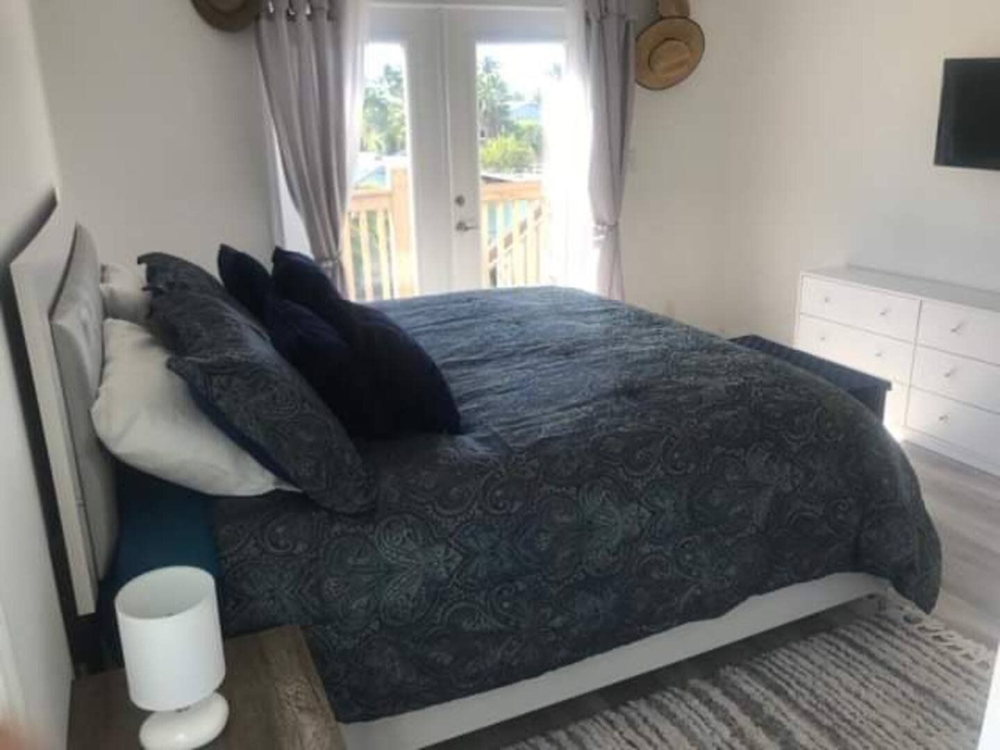 Master bedroom: king bed with navy linen and doors to the balcony