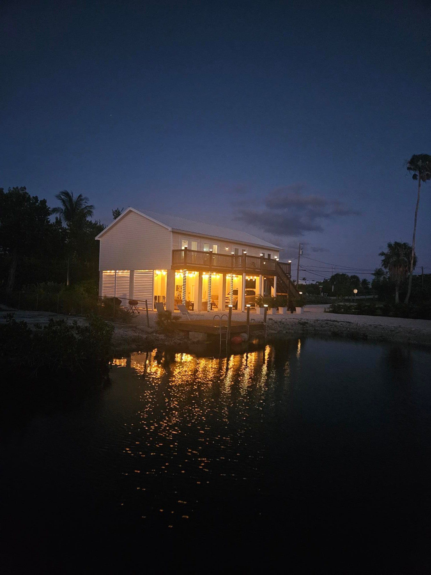 The house lit up at dusk, reflected in the canal