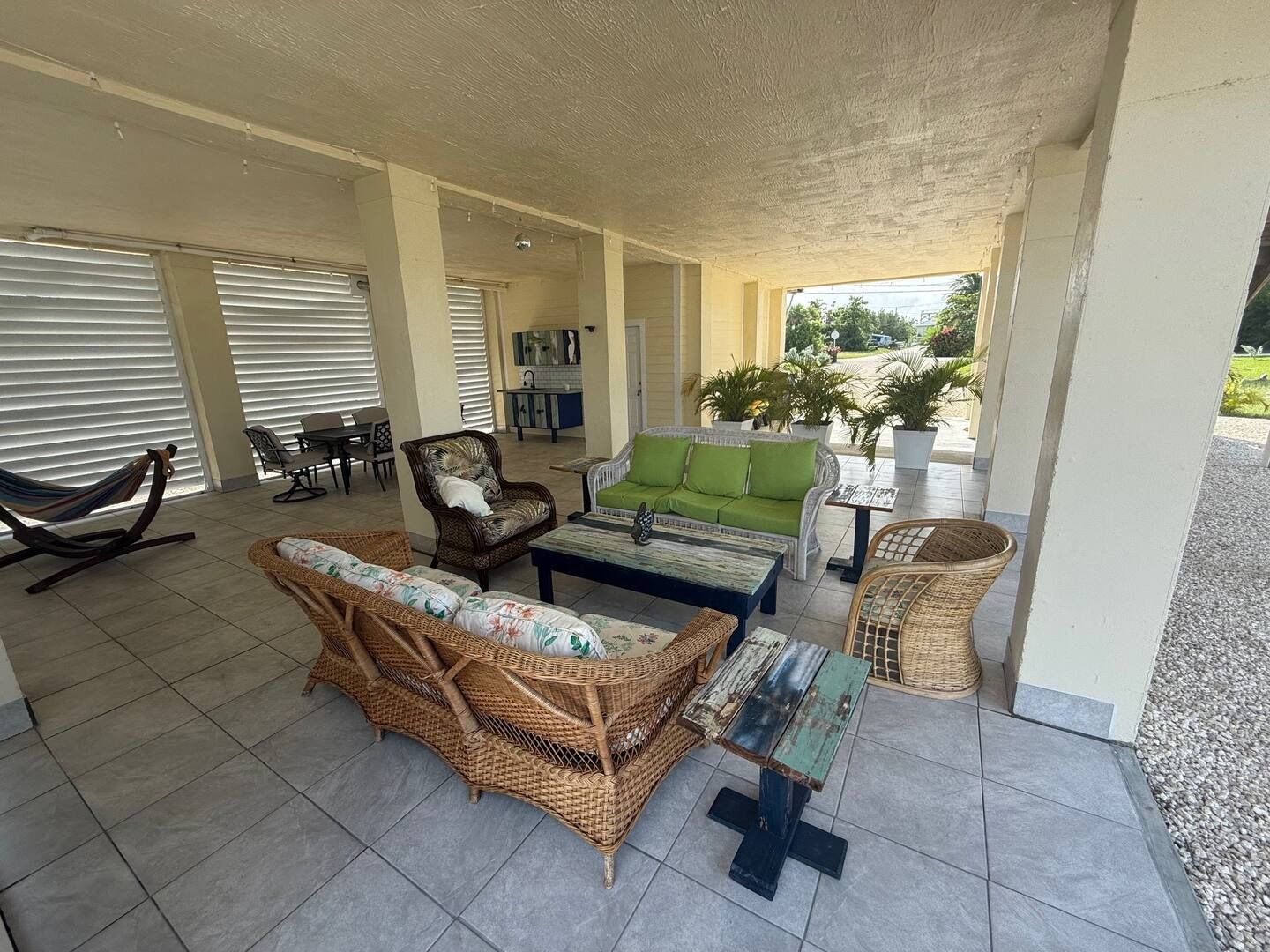 Wicker sofas and a coffee table in the shade of the patio