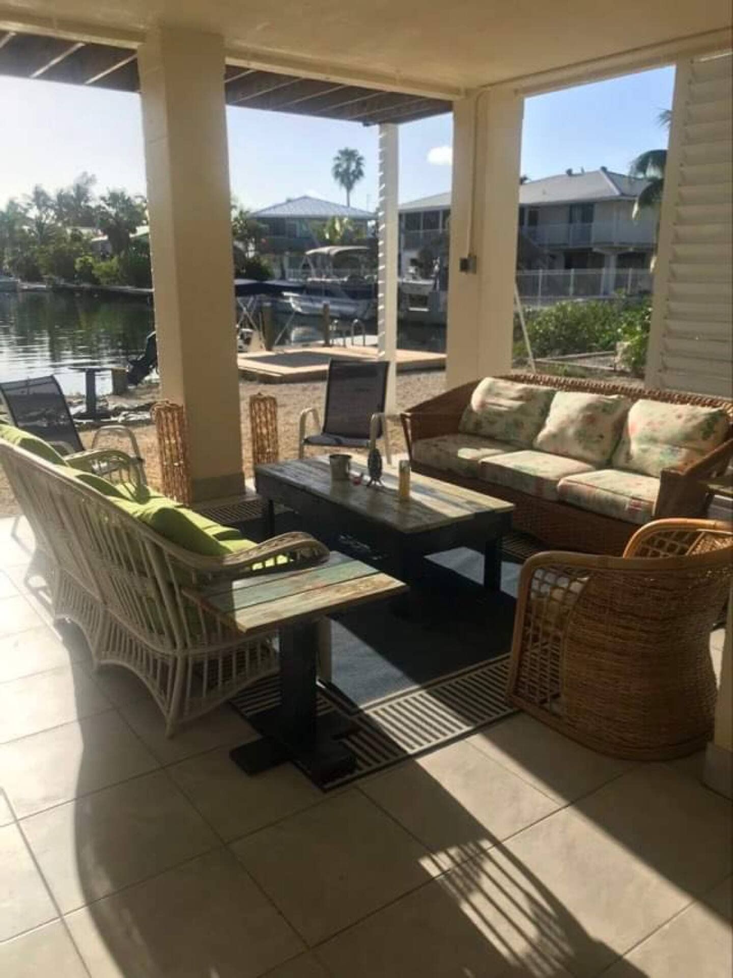 Patio sofas with green cushions looking out to the water