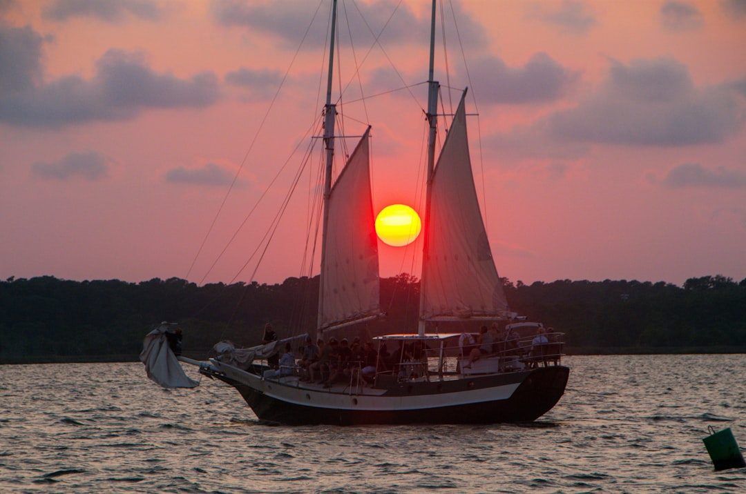 A two-masted schooner under sail at sunset